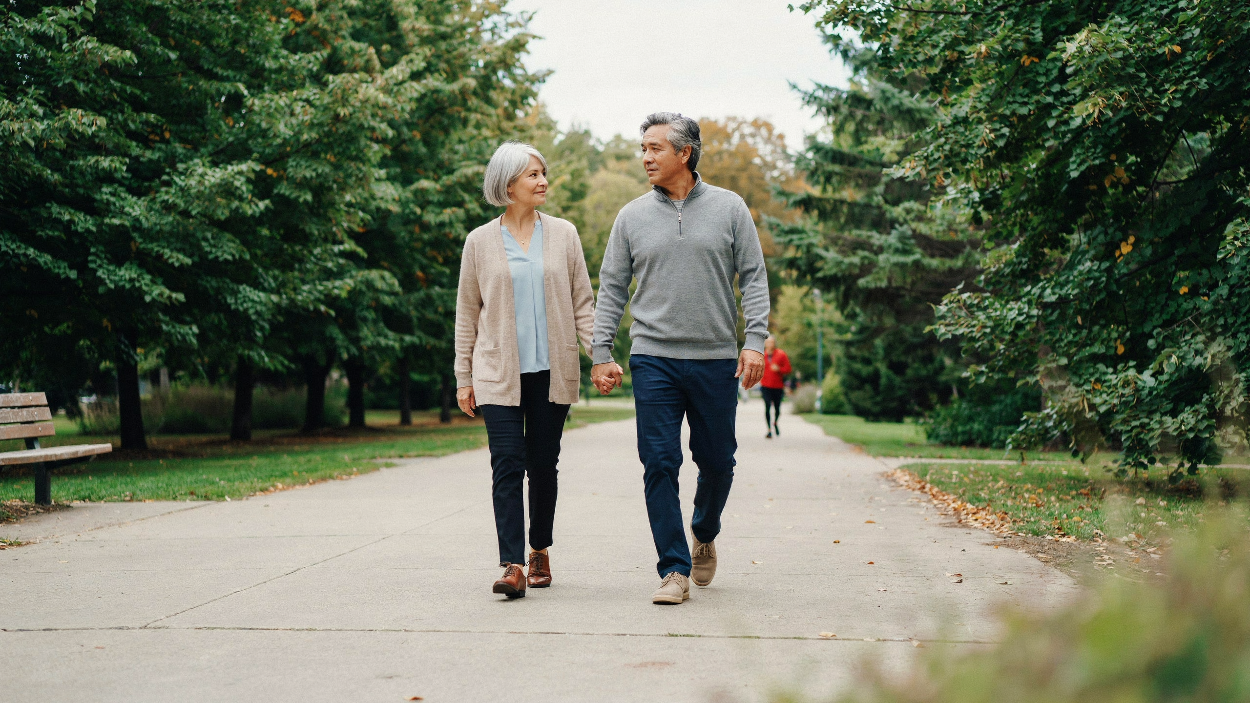 Two adults walking together on a level park path